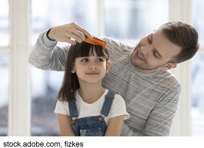 a father combing his daughter's hair